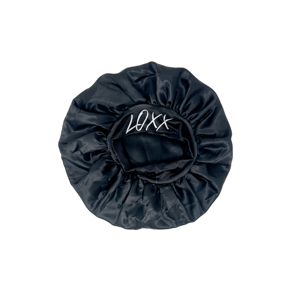 Black satin bonnet with elastic band featuring LOXX logo, perfect for protecting hair while sleeping.