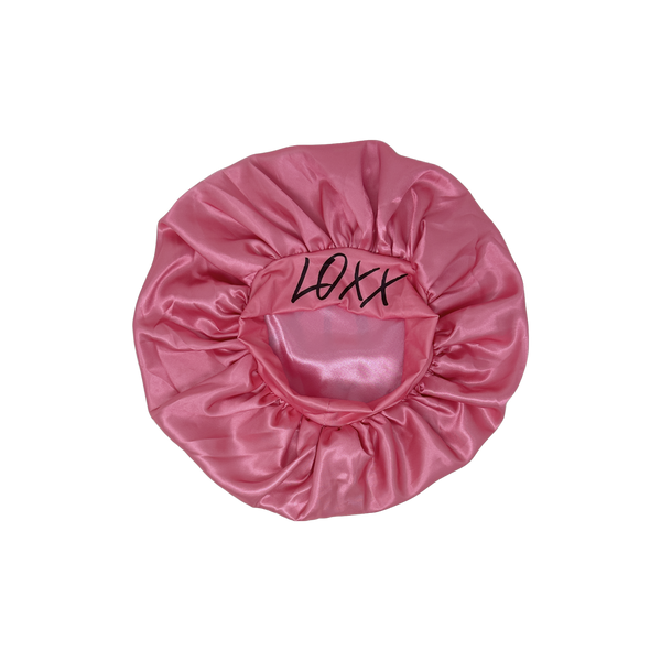 Pink satin bonnet with elastic band, branded 'LOXX', perfect for protecting hair while sleeping.