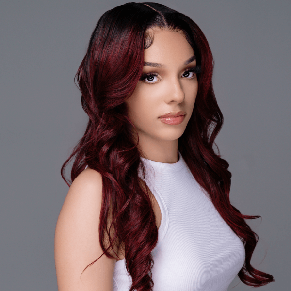 Model showcasing HD #99J Burgundy/Black roots lace frontal wig with natural hairline and flowing curls.